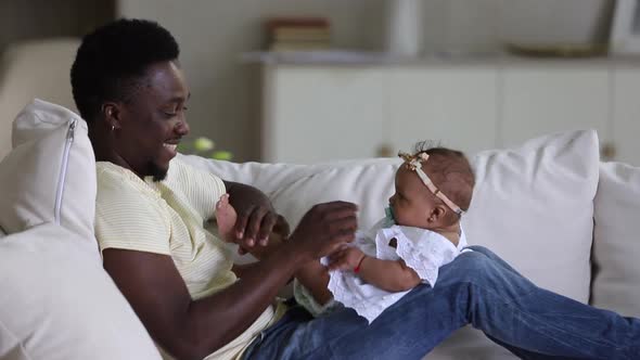 Affectionate Dad Playing with Infant Daughter alt