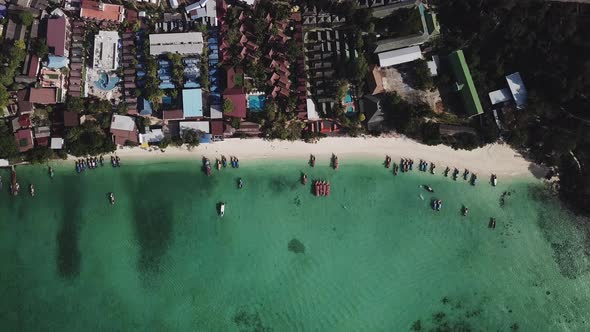 Aerial Top view Longtail fishing boats and village in the tropical sea at phi phi island beach Thail