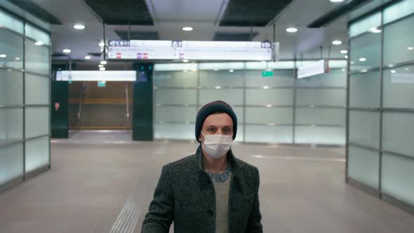 Man in Mask Walks with Suitcase in Airport. SARS-CoV-2 Coronavirus Pandemic