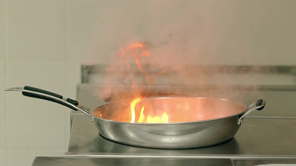 Close Up Frying Pan with Oil is Ignited on Frying Plate alt