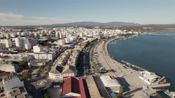 Portimao city and seafront promenade, Portugal. Aerial backward ascendent alt