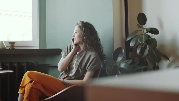 Pretty Woman Answering Call and Talking on Phone in Office Lounge Zone alt