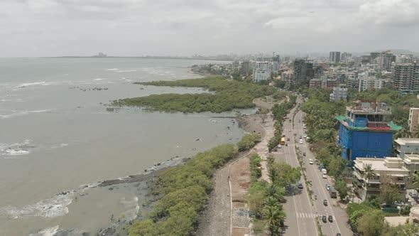 Drone dollying over a road adjacent to the sea alt