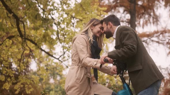 Handsome young couple in the autumn park with electrical bicycle