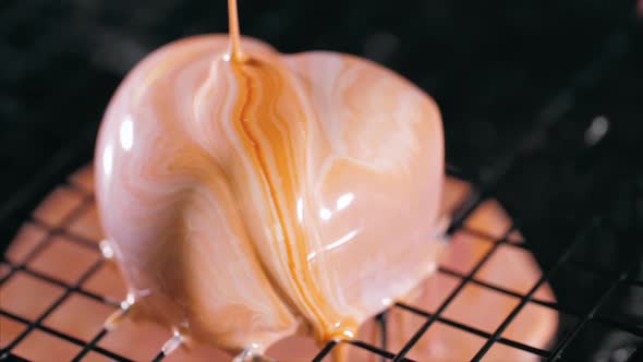 Close-up of a Pouring Glazing Over Heart Shape Dessert in Slow Motion.