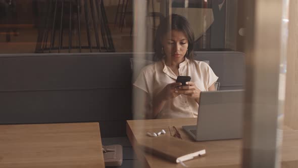 Woman Using Smartphone in Cafe alt