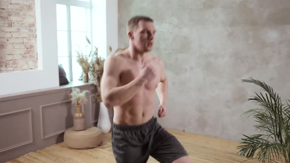 A Young European Man Works Out on the Background of the Grey Wall
