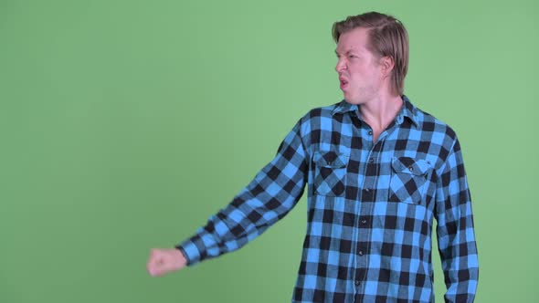 Stressed Young Hipster Man Pushing Something and Looking Disgusted alt