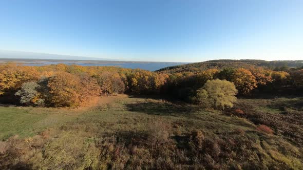 FPV Aerial Drone View. Flying Above Autumn Forest Hills Near Dnipro River