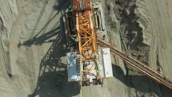 A Large Orange Bucketwheel Excavator in a Coal Mine Aerial View alt