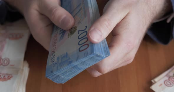 Male Hands Counting Money. Russian Money Banknotes of 2,000 Rubles