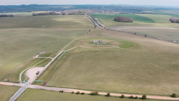 Dolly forward drone shot of Stonehenge towards A303 highway alt