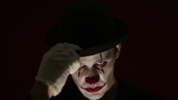 Terrible Clown Looks at the Camera and Laughs Terribly. Terrible Man in a Clown Makeup Takes Off His
