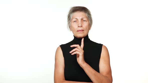in Slowmotion Senior Serious Woman Thinking Hard Gesturing with Index Finger Finally Figure Out alt