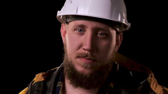 Foreman Engineer Straightens White Helmet and Looks at the Camera. The Real Boss, Man in Yellow