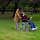 wheelchair user -woman with paraplegia accompanied by her boyfriend at park - VideoHive Item for Sale