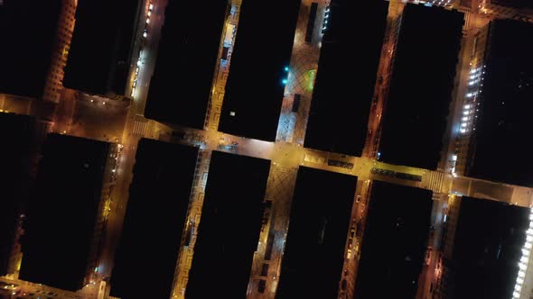 Ascending Aerial Overhead Top Down Night View of Rooftops of Rows of Houses in Urban City Center of alt