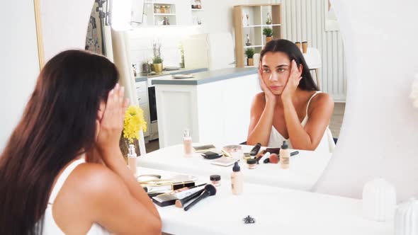 Woman with Towel Wrapped on Her Head Applying Moisturizing Face Cream alt