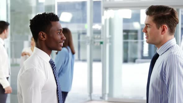 Business executives interacting in office alt