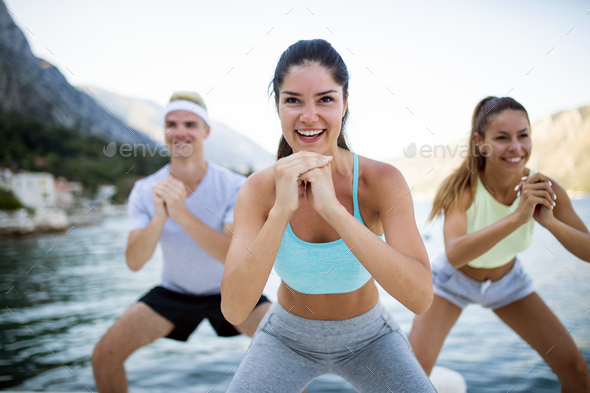 Group of happy people exercising outdoor. Sport, fitness, friendship and healthy lifestyle concept - Stock Photo - Images