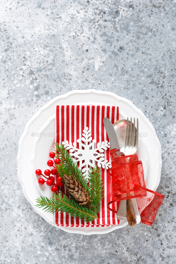 Christmas table setting with empty festive white plate and cutlery ...
