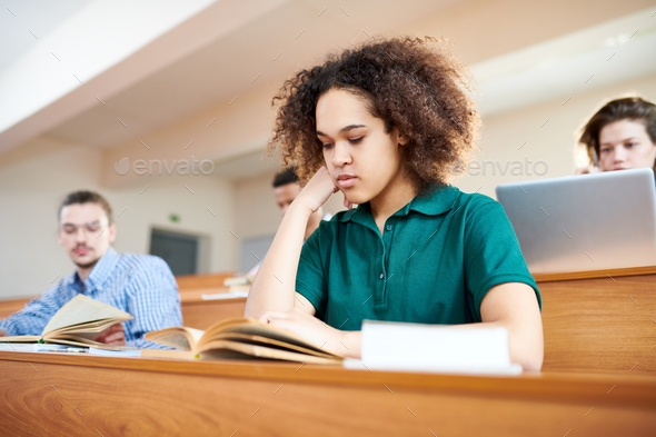 Concentrated African-American student reading textbook - Stock Photo - Images