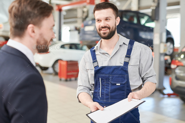 Mechanic Offering Contract to Client Stock Photo by seventyfourimages