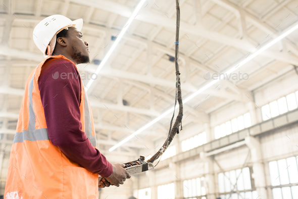 Construction worker using crane controller - Stock Photo - Images