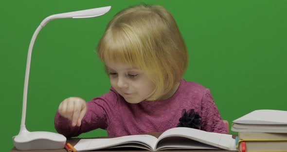 Girl Drawing at the Table. Education Process in Classroom. Chroma Key alt