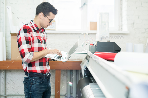 Man with laptop working in printing office