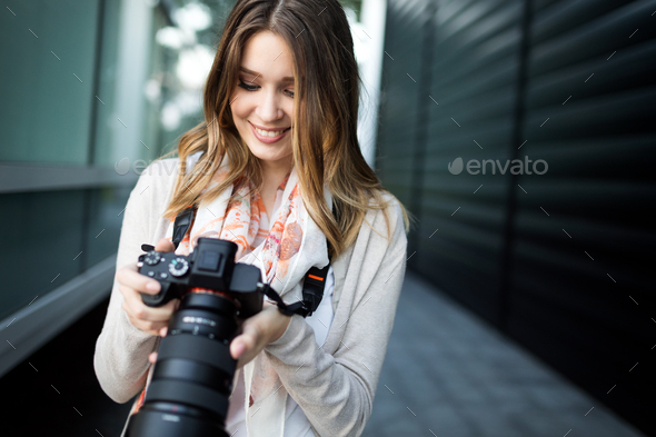 Woman is a professional photographer with dslr camera, outdoor and sunlight - Stock Photo - Images