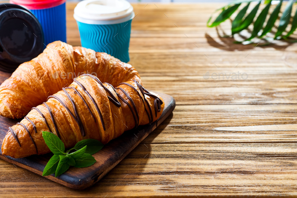 To Go breakfast croissant and coffee on wooden background , copy space