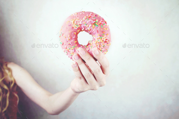 Hand holding a pink donut - Stock Photo - Images