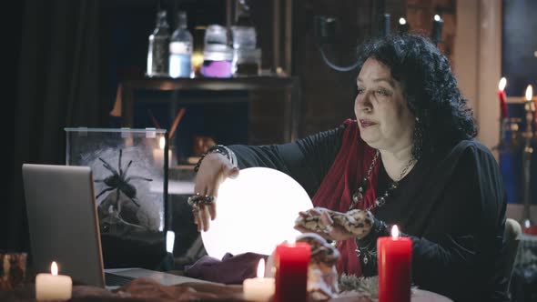 Seer Holding Witch and Reading Future for Client Online Using Crystal Ball alt