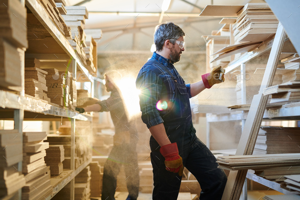Serious furniture worker finding detail at warehouse