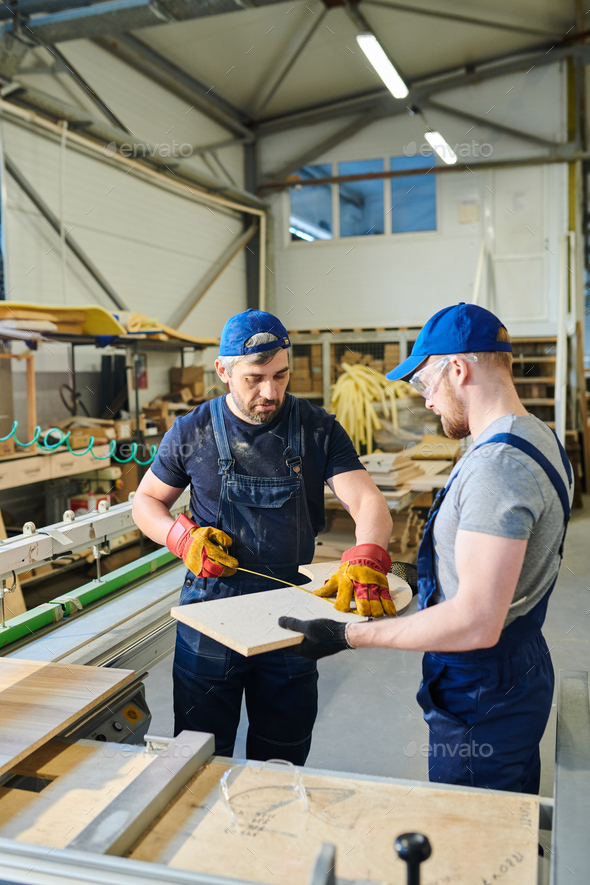 Modern furniture worker using ruler at factory Stock Photo by
