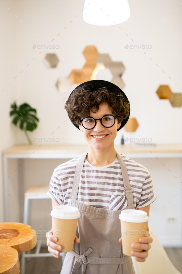 Cheerful barista offering to drink coffee - Stock Photo - Images