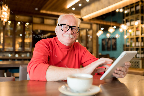 Content elderly man connecting to wifi in cafe