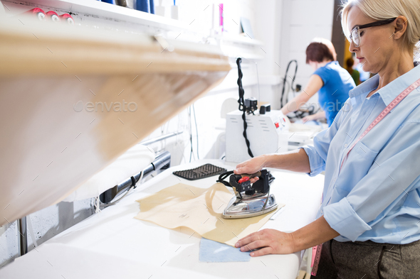 Woman Ironing Clothes in Atelier - Stock Photo - Images