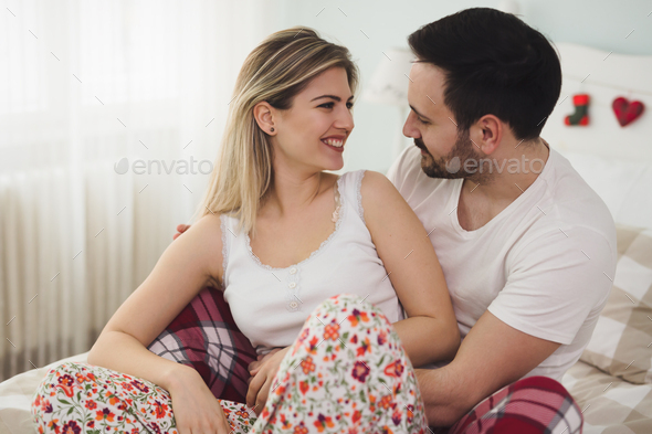 Couple in love wearing pajamas lying in bed - Stock Photo - Images