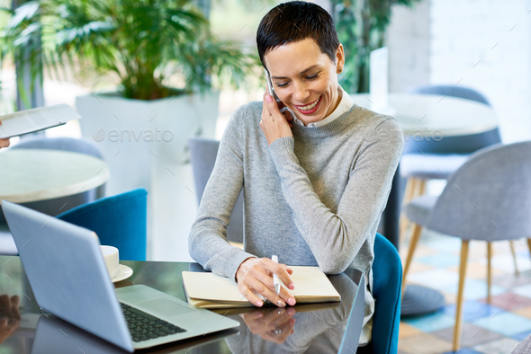 Smiling Businesswoman Speaking by Phone with Client