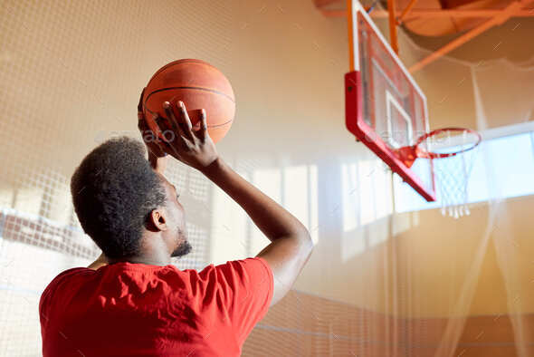 Black man throwing basketball ball