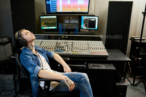 Man listening to music in studio - Stock Photo - Images