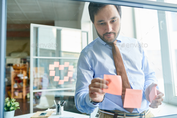 Creative man arranging stickers on board - Stock Photo - Images