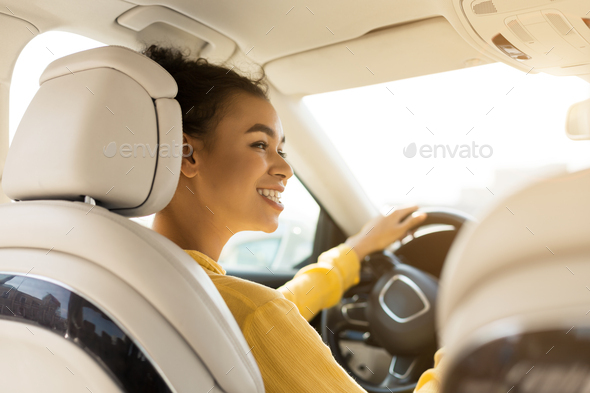 Happy african american girl driving car and smiling - Stock Photo - Images