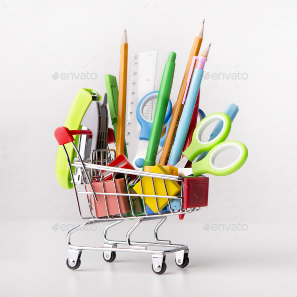 Close up of shopping cart with office supplies isolated on white - Stock Photo - Images
