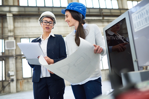 Positive female engineers discussing plan - Stock Photo - Images