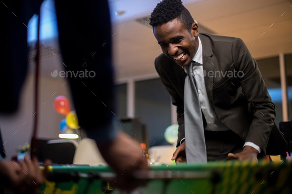 Businessman playing table football - Stock Photo - Images