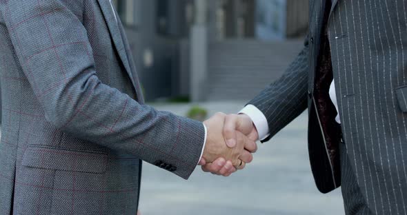 Close up of the Hands of Top managers in Business Suits Shake Hands With Each Other alt