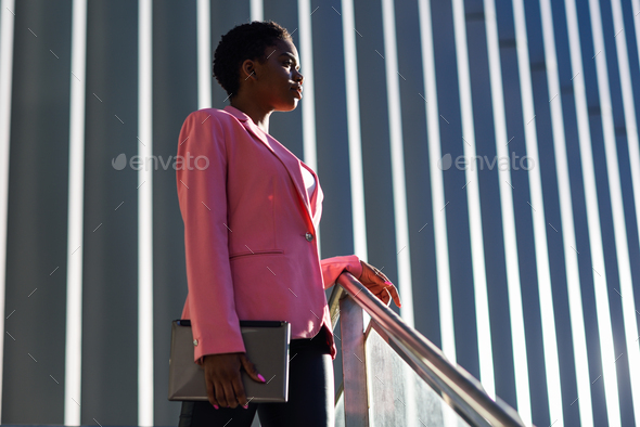 Black businesswoman standing near business office building - Stock Photo - Images